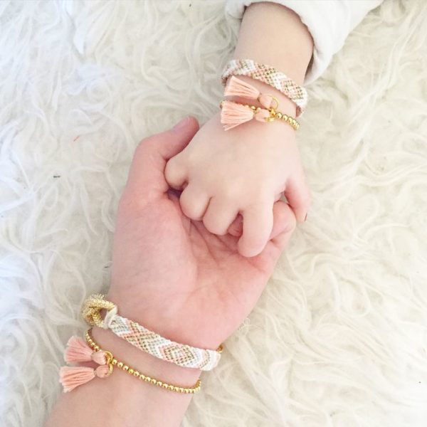 Mother And Child Holding Hands Wearing A Bracelet