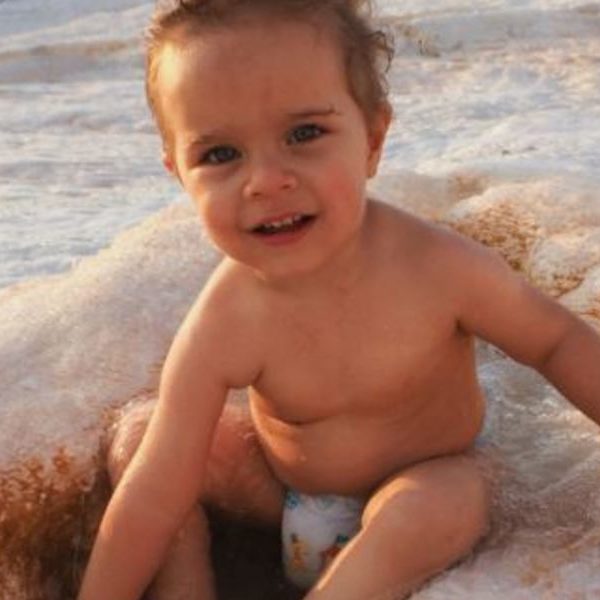 Child Sitting At The Beach